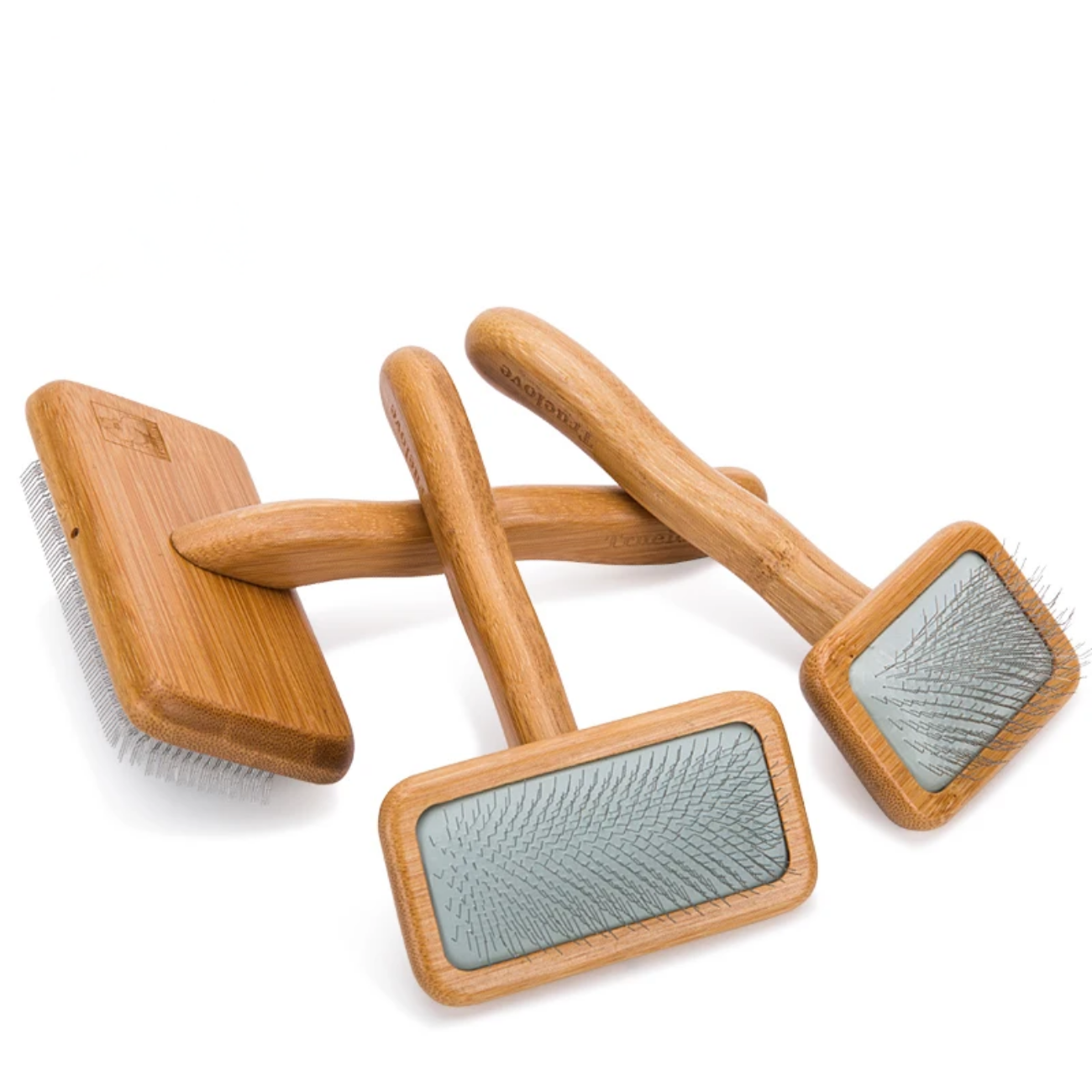 Set of wooden pet grooming brushes with gray bristle pads on a white background