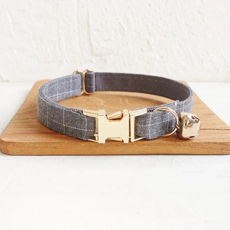 Gray dog collar with gold buckle on a wooden board against a white background