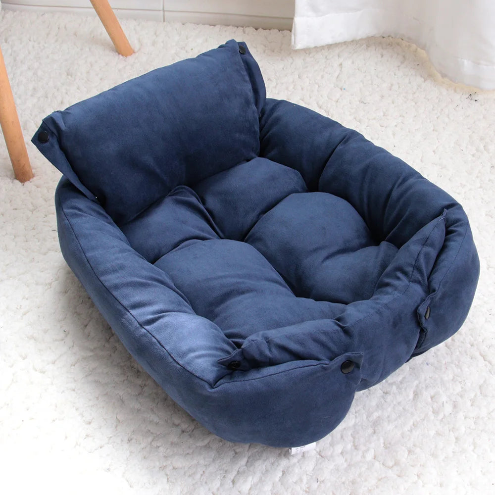 A navy cushioned convertible pet bed arranged in sofa style on a white rug.