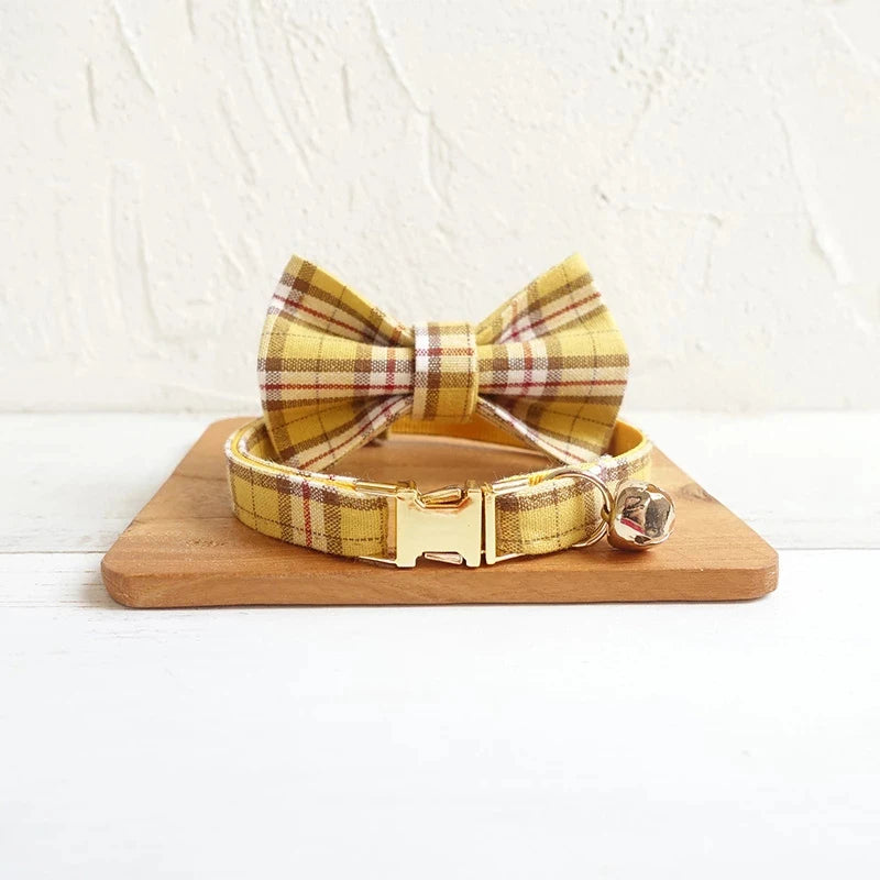 Yellow Plaid dog collar and bow tie set on a wooden board with a white background