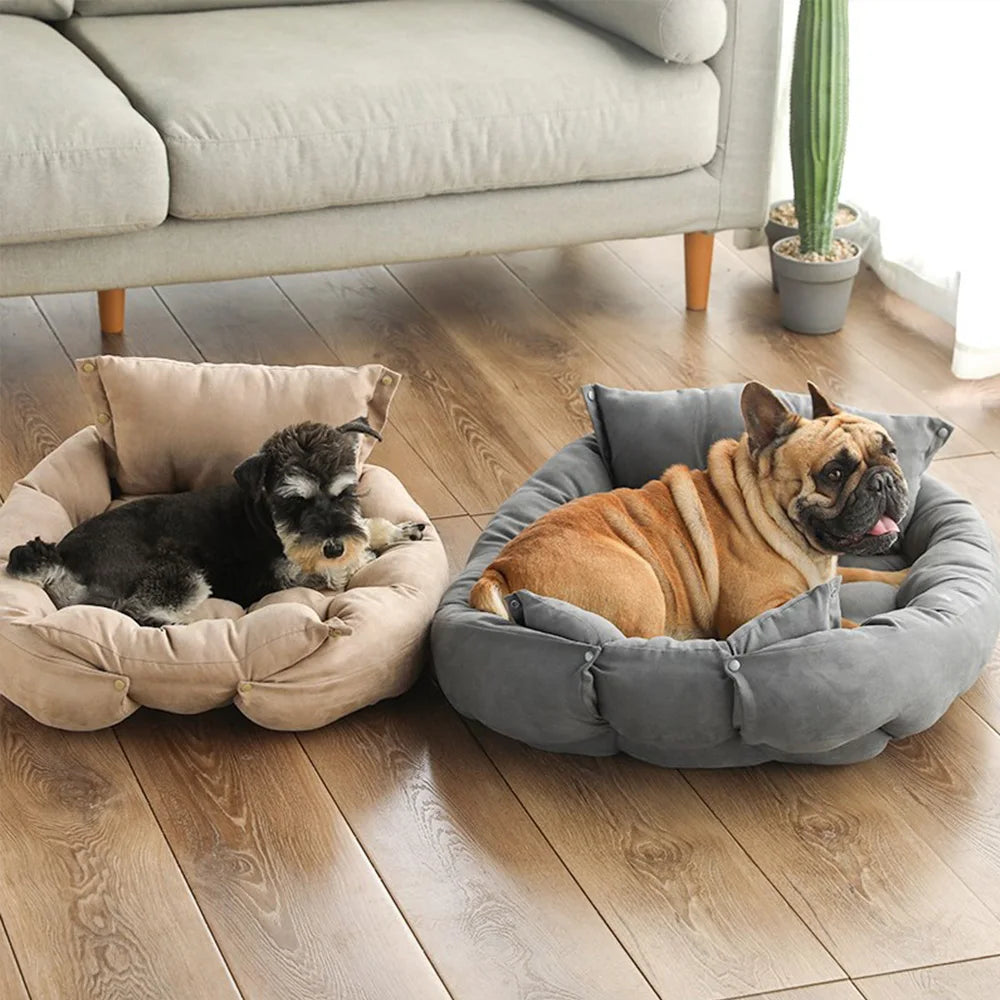 Two dogs, one small and one medium-sized, lounging comfortably in two versions of the cushioned pet bed, one beige and one gray.