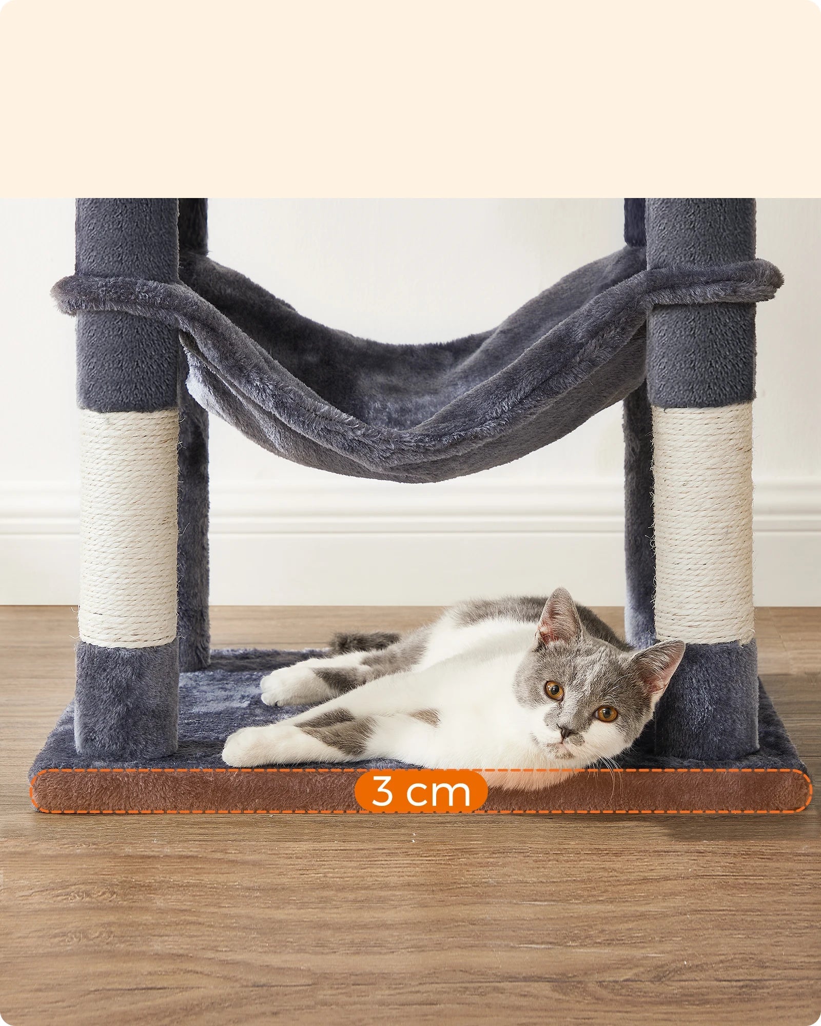 Cat lounging on the base of a cat tree with reinforced 3 cm wooden support and hanging hammock above.