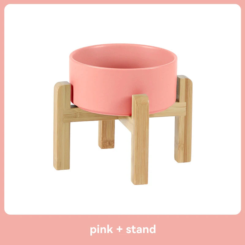 Pink elevated ceramic pet bowl on a wooden stand