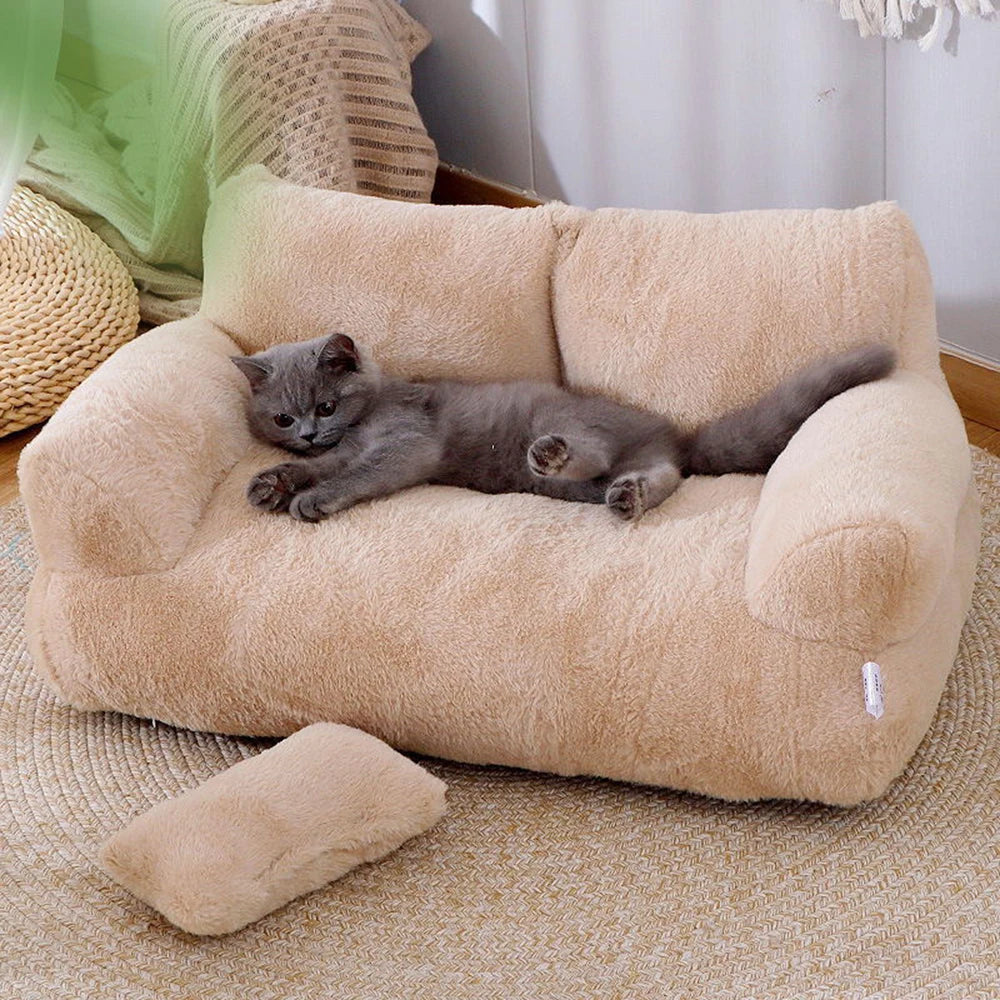 Gray cat lounging on beige plush sofa pet bed with bolstered arms.
