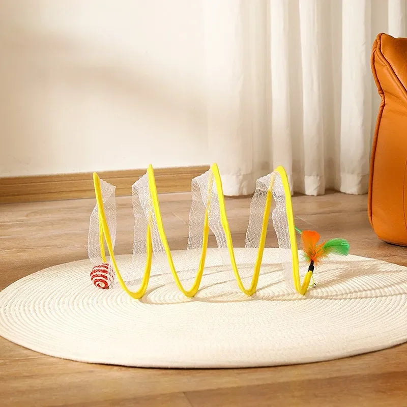 Pet toy with yellow hoop and feathered toy on a wooden floor.