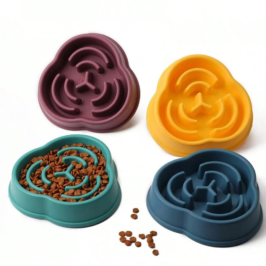 Four petal-shaped silicone pet bowls in different colors with maze designs