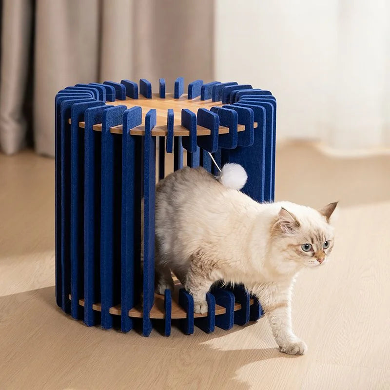 White cat walking out of a blue modular cat house with open slatted walls.