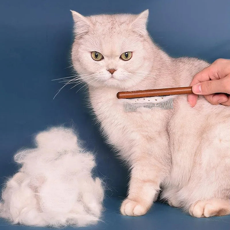 White cat being groomed with GroomCraft Pet Comb, loose fur collected
