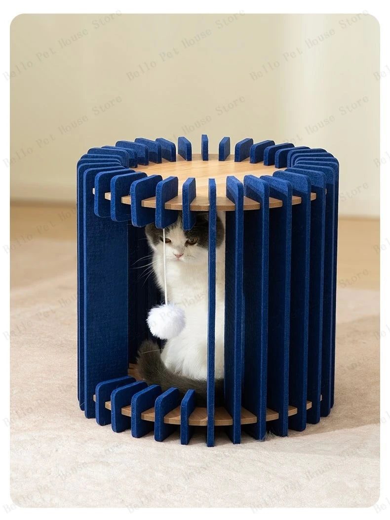 Cat sitting inside a cylindrical blue cat house with slatted design and hanging plush toy