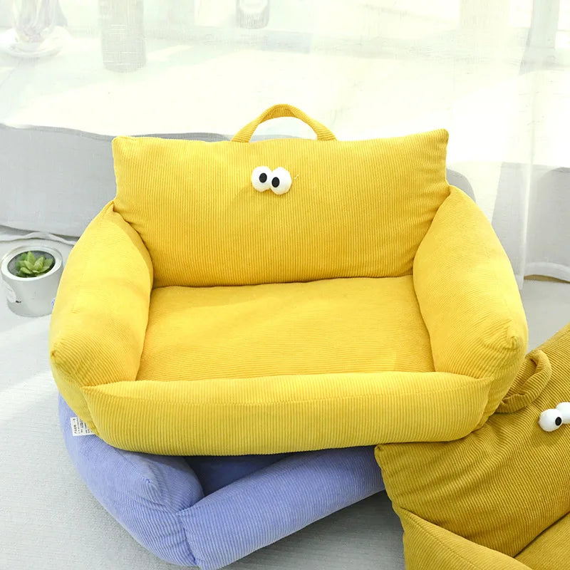 Bright yellow velvet pet bed with cartoon eyes and portable carry handle.