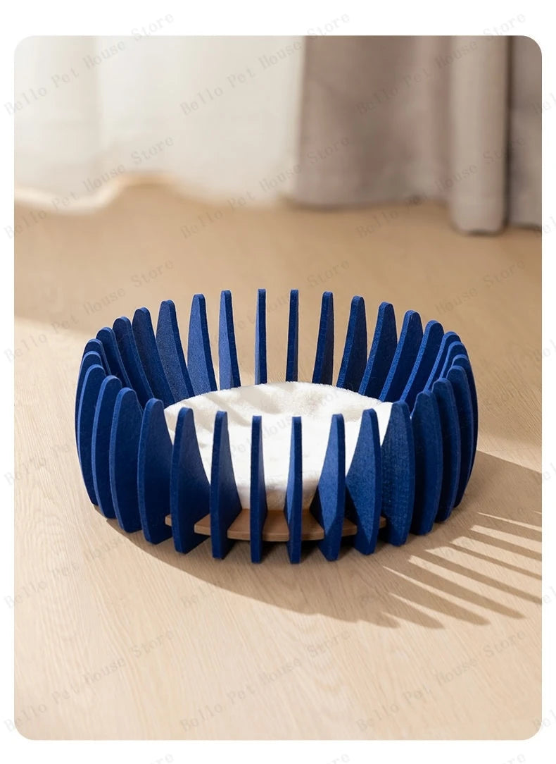 Modern round blue cat bed with open slotted sides and soft white cushion inside.