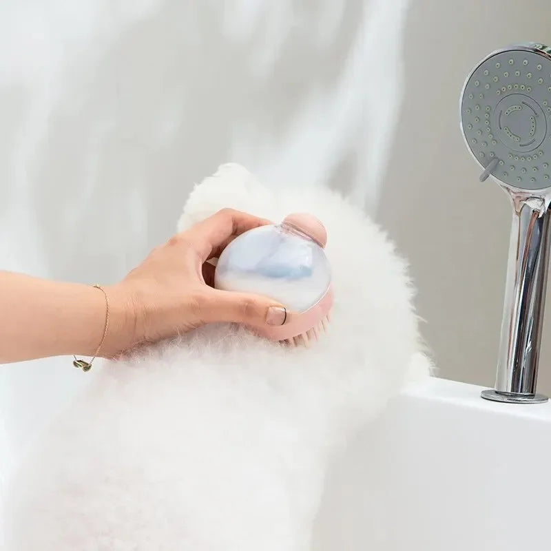 Person using MellowBubbs™ Pet Bath Brush on fluffy white dog during bath.