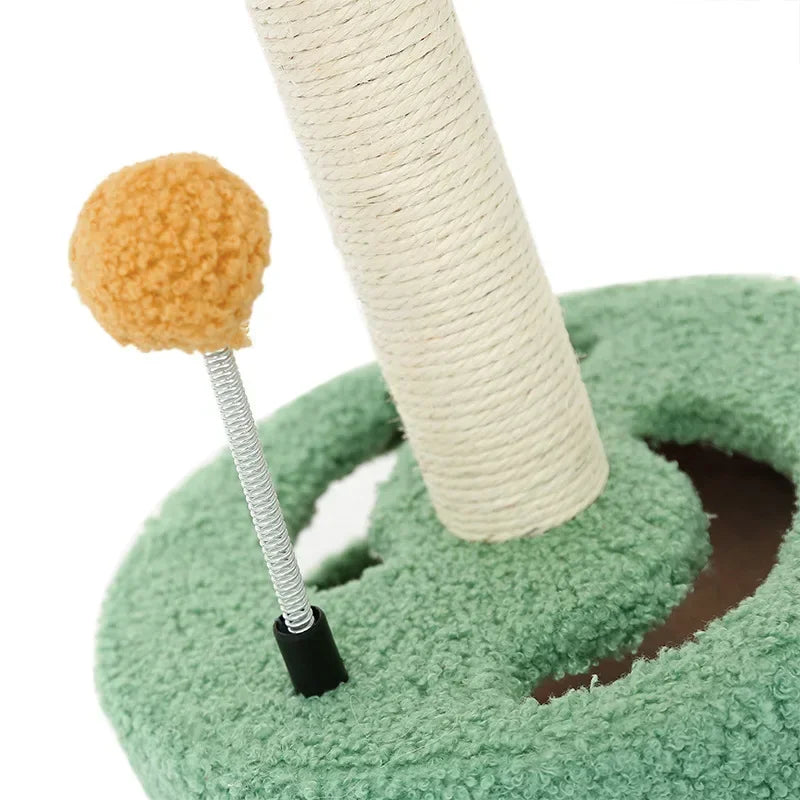 Green carpeted base with a spring toy topped with a yellow pom-pom ball attached next to a scratching post.