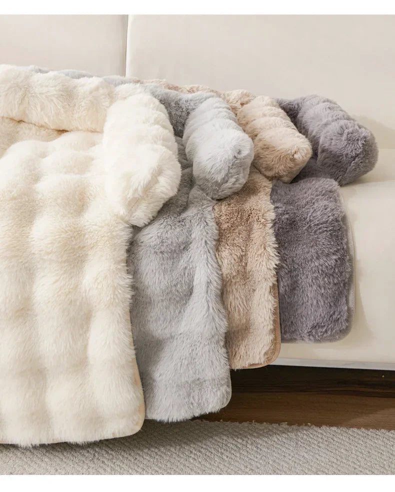 Collection of fluffy pet mat beds in various colors on a couch.