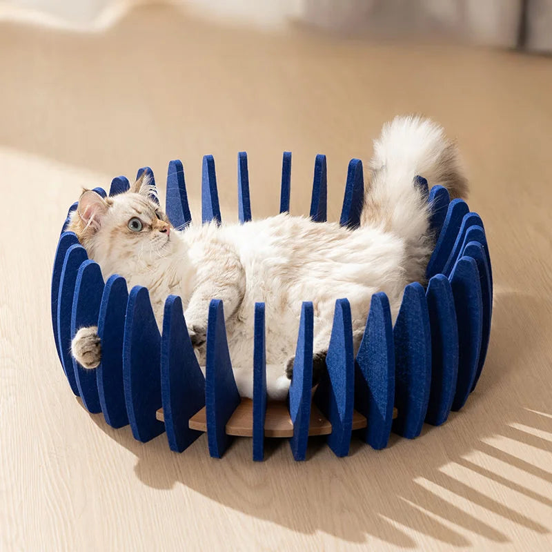 White cat lying comfortably in a blue modular round pet bed with open sides.