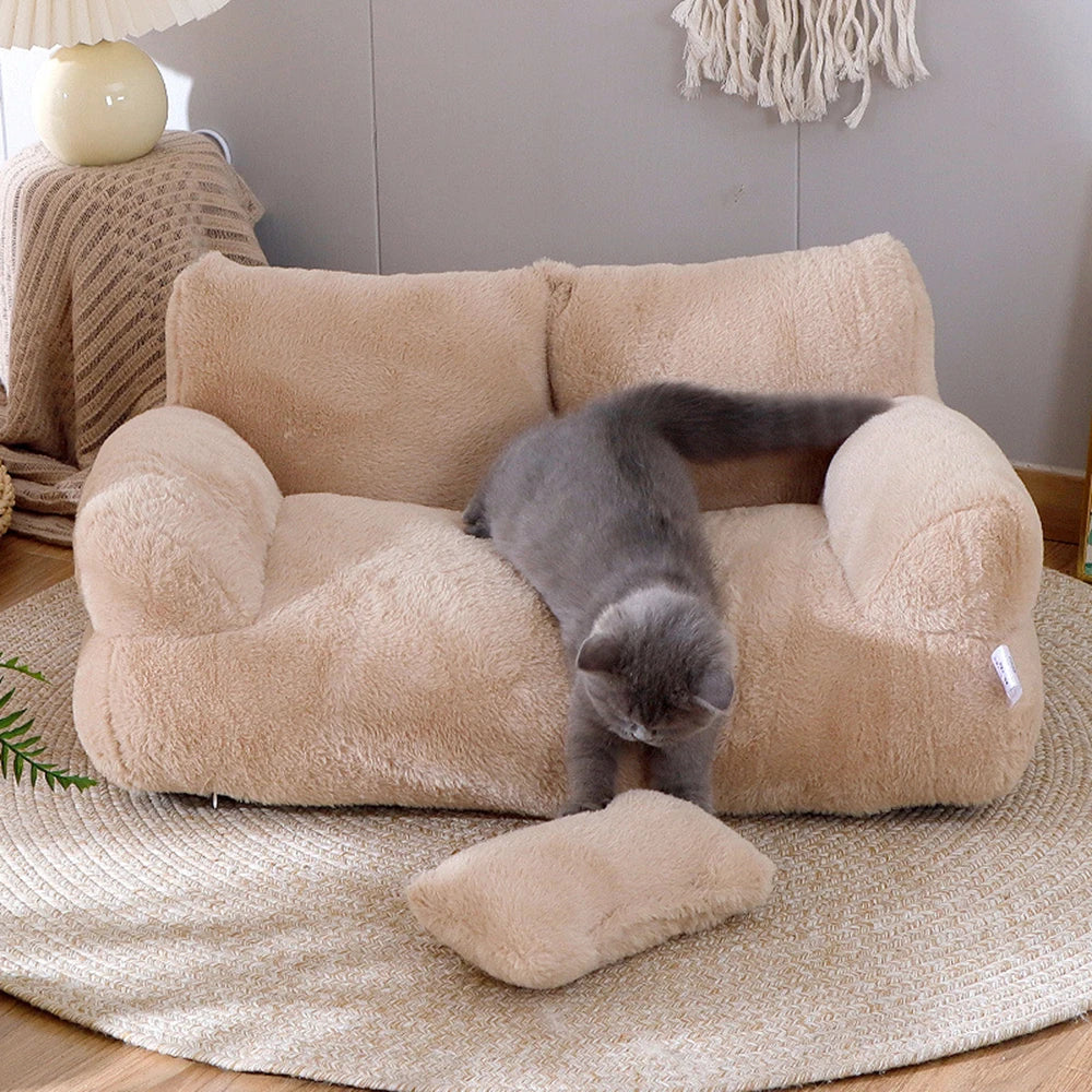 Cat playing on sofa-style pet bed with matching cushion.