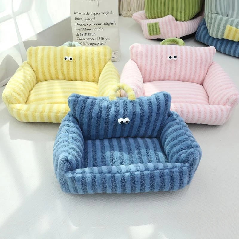 Blue velvet pet bed with high side cushions and fun googly eyes.