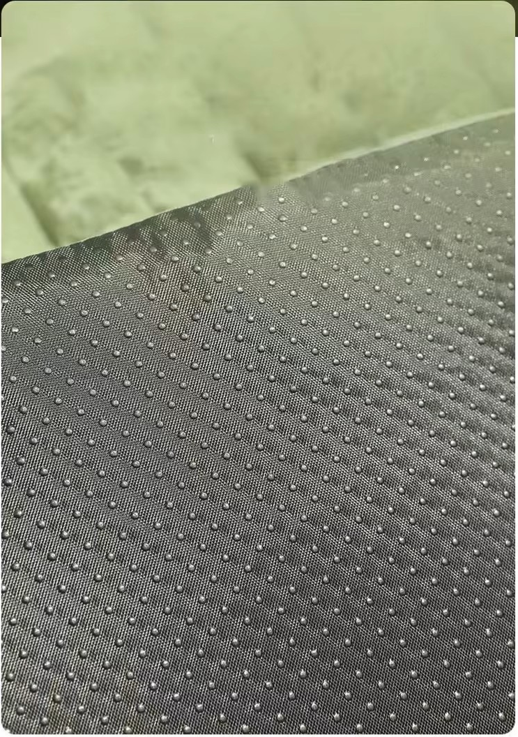Close-up of non-slip bottom fabric on plush dog bed with textured grip dots.